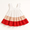 White dress with red and beige ruffled layers on a white background
